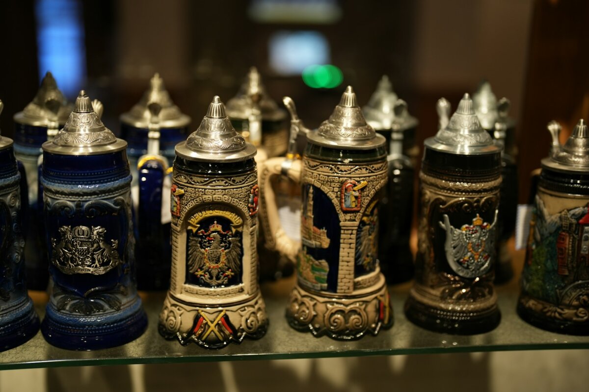 a row of beer mugs sitting on top of a glass shelf